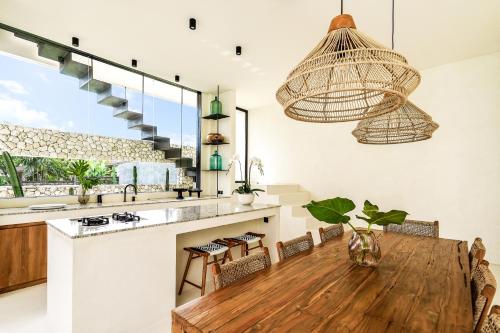 チャングーにあるCasa Umalas Villa by Betterplaceのキッチン、ダイニングルーム(木製テーブル付)