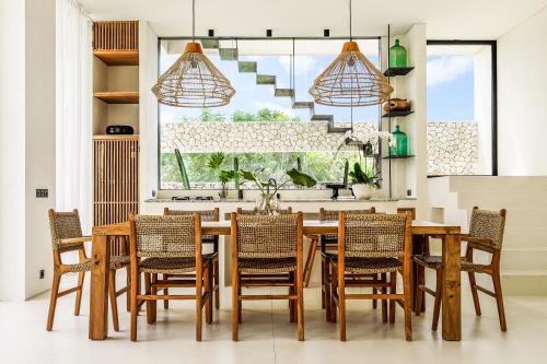 a dining room with a wooden table and chairs at Casa Umalas Villa by Betterplace in Canggu