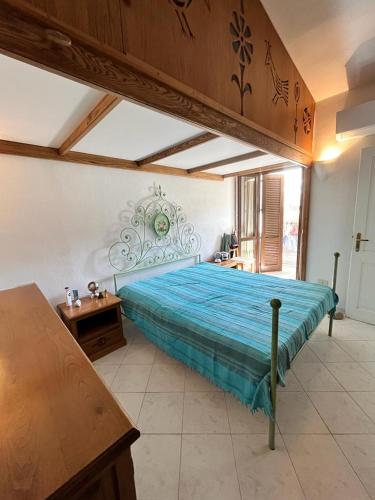 a bedroom with a large bed with a blue bedspread at bilocale vista porto in Cannigione