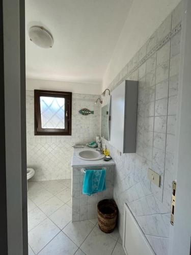 a white bathroom with a sink and a toilet at bilocale vista porto in Cannigione