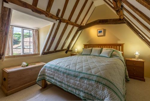 a bedroom with a bed and a window at Holly Cottage in Huntingfield