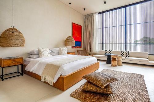 チャングーにあるCasa Umalas Villa by Betterplaceの大きなベッドと大きな窓のある寝室