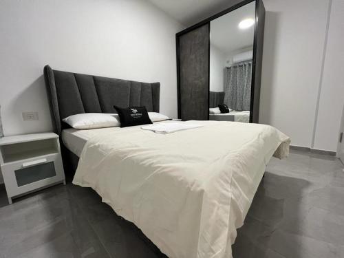 ein Schlafzimmer mit einem großen Bett und einem großen Spiegel in der Unterkunft דירת 2 חדרים in Bat Yam