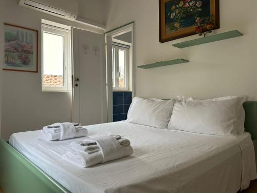 a white bed with towels on top of it at Padova Umberto center appartments in Padova