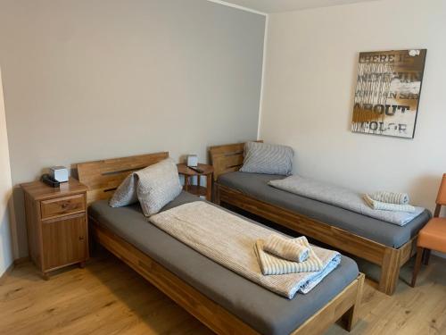 a room with two beds and a desk and a table at Roccos Raum in Kapfenberg