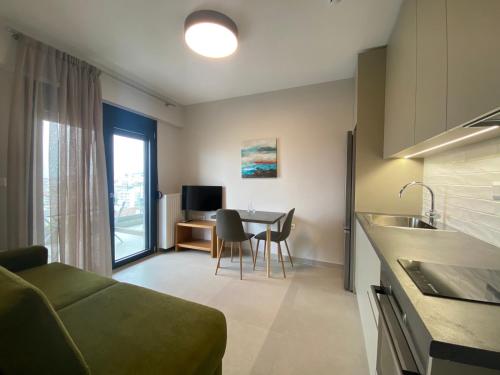 a kitchen and living room with a couch and a table at Toumba apartments in Thessaloniki