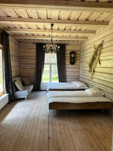 a bedroom with two beds in a wooden room at Vilkes Villa Ezero namas in Bertašiūnai