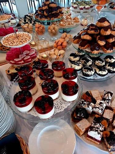a table filled with different types of pastries and desserts at Hotel i Restauracja 13 Smaków in Częstochowa
