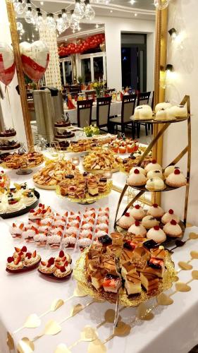 a buffet of desserts and pastries on a table at Hotel i Restauracja 13 Smaków in Częstochowa