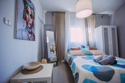 een slaapkamer met een bed, een tafel en een spiegel bij Central Haifa Quite Place in Haifa