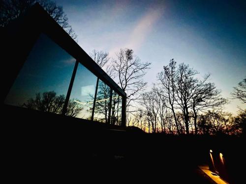 een gebouw met een raam met bomen op de achtergrond bij ForRest Boutique Cabin in Dunabogdány