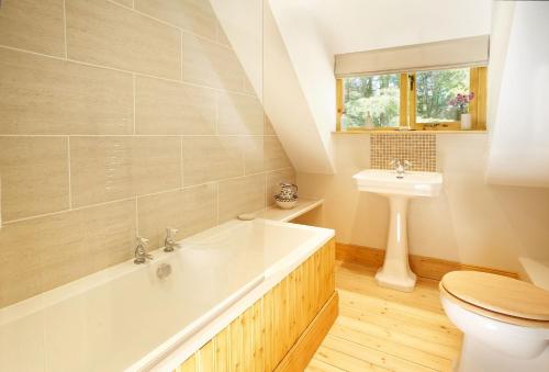 a bathroom with a bath tub and a sink at Deerpark Lodge in Ashby de la Zouch