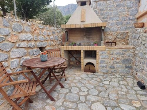 un patio al aire libre con una mesa y un horno de pizza en Mani spot in Yerolimin, en Yerolimin
