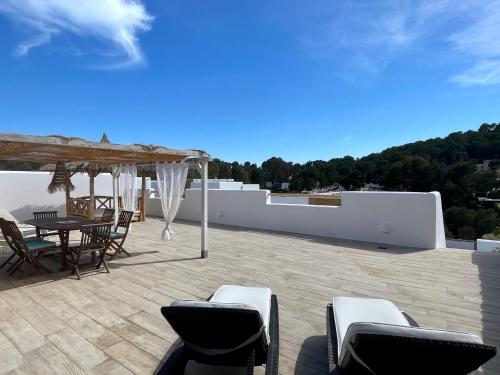 eine Terrasse mit einem Tisch und Stühlen auf dem Dach in der Unterkunft Casa Maria Sunset in Cala Vadella