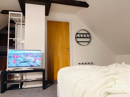 1 dormitorio con 1 cama y mesa con TV en Scandinavian Apartment Hotel - Prison Museum 1- one room apartment, en Horsens