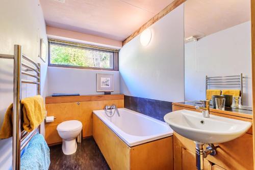 a bathroom with a sink and a tub and a toilet at The Shippen in Membury