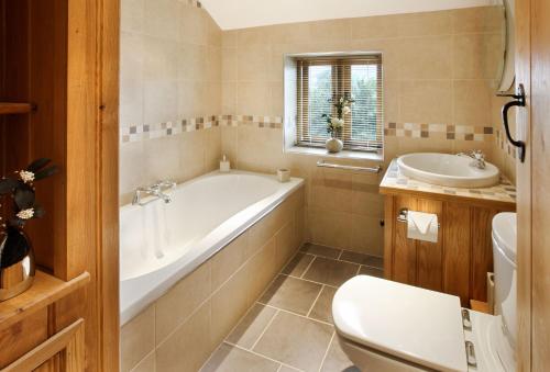 a bathroom with a tub and a sink and a toilet at Llancayo Windmill in Monkswood