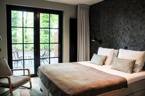 - une chambre avec un lit, une chaise et une fenêtre dans l'établissement Veluwe Hotel de Beyaerd, à Hulshorst