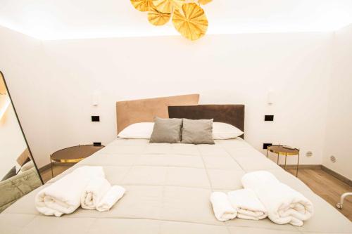 - une chambre avec un grand lit blanc et des serviettes dans l'établissement Malià Sea House, à Bari