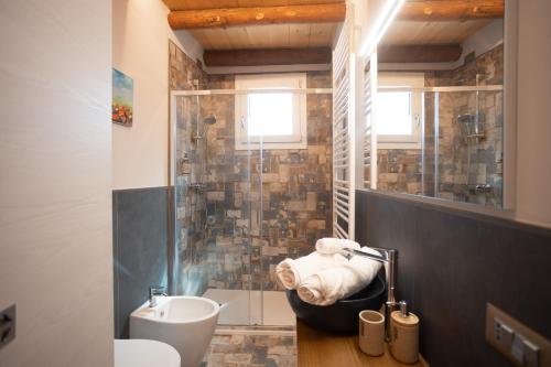 La salle de bains est pourvue d'un lavabo, de toilettes et d'une douche. dans l'établissement B&B Basta Bussare, à Chioggia