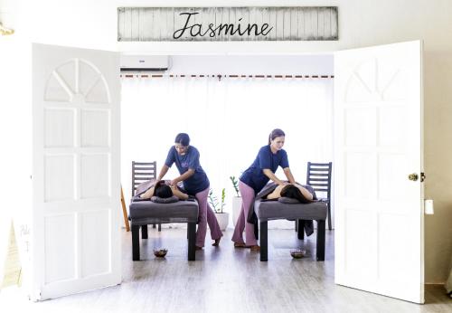 two women sitting on chairs in a room with doors open at Buena Vida Resort and Spa in Daanbantayan