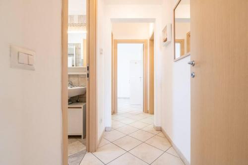 einen Flur eines Badezimmers mit einem Waschbecken und einer Tür in der Unterkunft -Villa Emily- Parking, Garden & Wi-Fi in Pisa