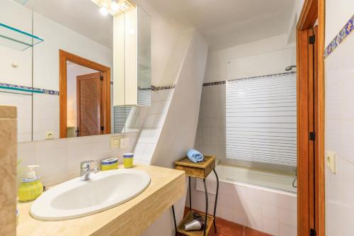 a bathroom with a sink and a mirror and a tub at Casa Torres in Pollença
