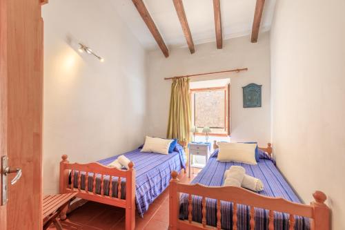 a bedroom with two beds and a window at Casa Torres in Pollença