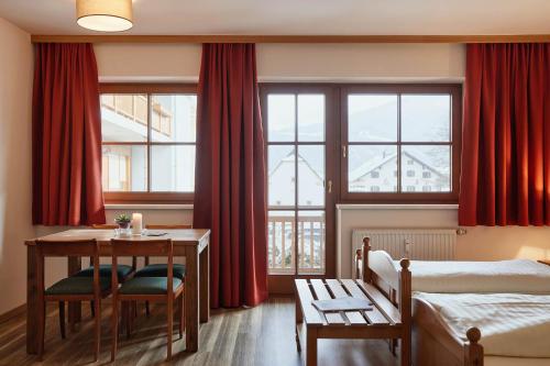 エープスにあるAppartement Oberwirt Ferienwohnungのベッド、テーブル、窓が備わるホテルルームです。
