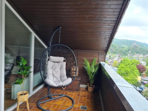 a wicker chair on the balcony of a house at Ferienhaus Am Reilsbach in Cochem