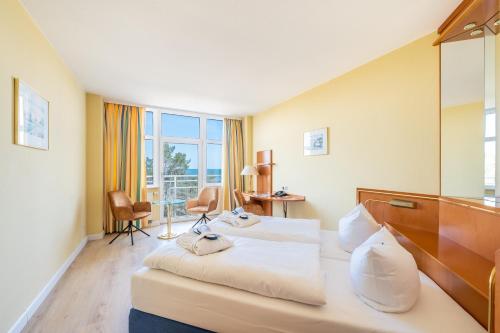 ビンツにあるArkona Strandhotelのベッド2台と窓が備わるホテルルームです。