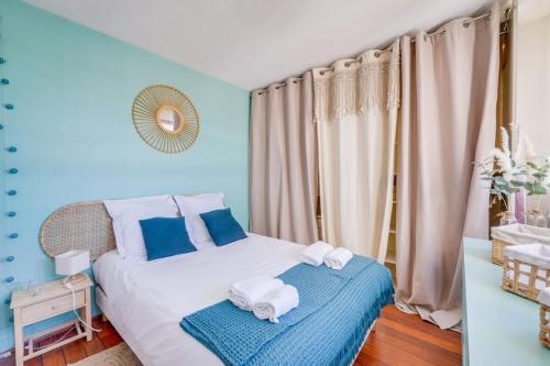 - une chambre avec des murs bleus et un lit avec des serviettes dans l'établissement Flat in the port of Arcachon, à Arcachon