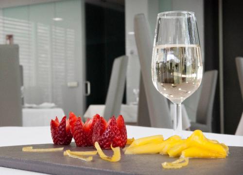 a plate of fruit and a glass of wine at Hotel Valle del Jerte in Jerte