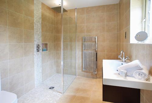 ein Bad mit einer Dusche und einem Waschbecken in der Unterkunft Endymion Lodge in Chappel