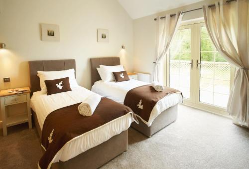 a bedroom with two beds and a window at Endymion Lodge in Chappel