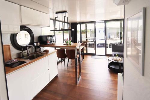 a kitchen with a table and a dining room at Hausboot La Mare Claudia in Weyhe