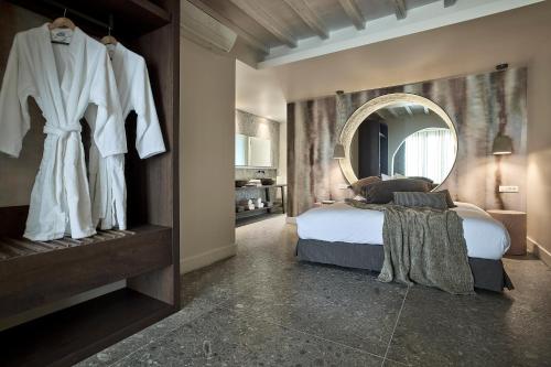 a bedroom with a bed and a large mirror at Amazon Mykonos Suites & Spa in Agios Ioannis Mykonos