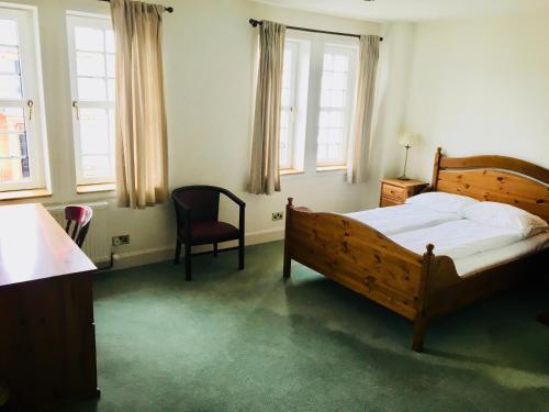 1 dormitorio con 1 cama, 1 silla y ventanas en Thornhill Inn en Thornhill