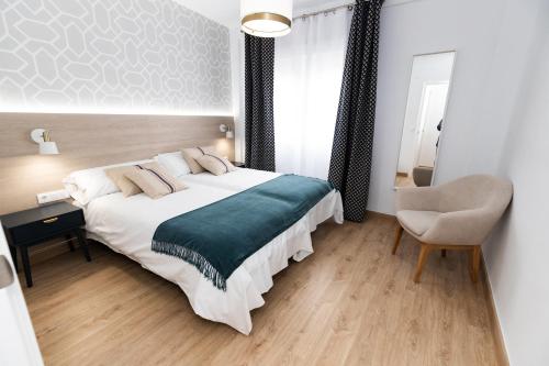 1 dormitorio con 1 cama grande y 1 silla en ALOJAMIENTOS LOS PEDROCHES, en Villanueva de Córdoba