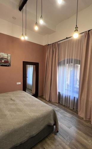 a bedroom with a bed and a large window at Chikhi in Tbilisi City