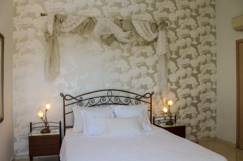a bedroom with a bed with white sheets and a wallpaper at Villa Kyriaki in Kalami