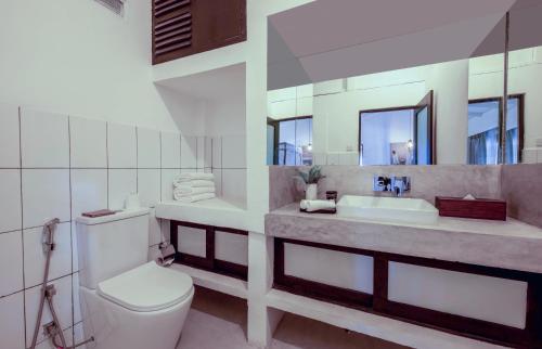 a bathroom with a toilet and a sink and a mirror at The Well House Galle Sri Lanka in Unawatuna