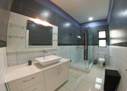 y baño con lavabo, ducha y aseo. en Oceanview 3-bedroom apartment, en Flic en Flac