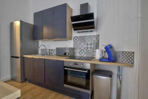 a kitchen with brown cabinets and a counter top at Boulevard de la Plage flat in Arcachon