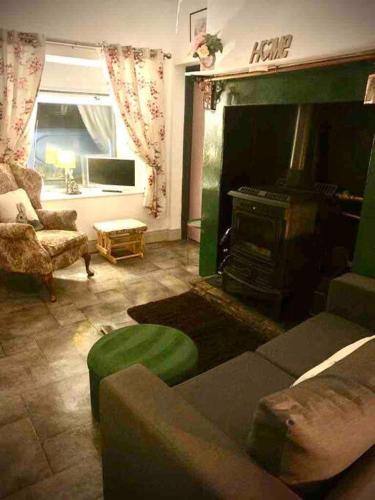 ein Wohnzimmer mit einem Sofa und einem Kamin in der Unterkunft Mary Grays Hideaway 2 Bedroom Irish Cottage 