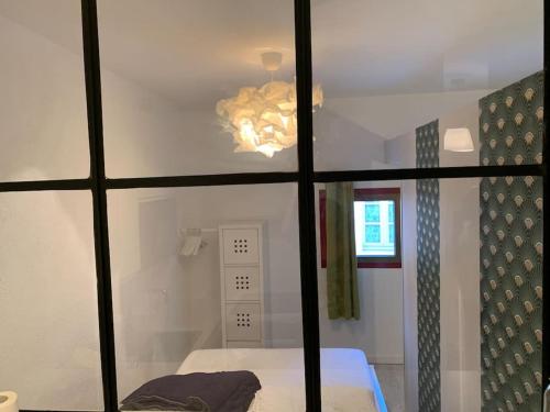 Cette chambre comprend un lit et une fenêtre. dans l'établissement Joli appartement au cœur de la ville, à LʼIsle-sur-la-Sorgue