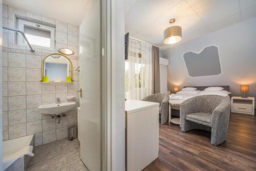 a bathroom with a sink and a bedroom with a bed at Tokajer Wellness Panzió in Keszthely