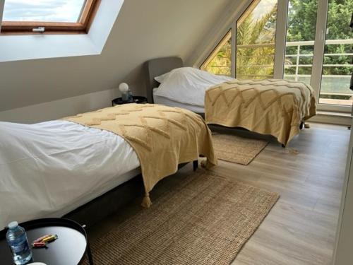 a bedroom with two beds and a large window at Villa Margaux in Lampertheim
