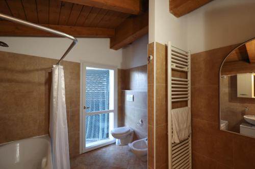 La salle de bains est pourvue d'une baignoire, de toilettes et d'une fenêtre. dans l'établissement Villa Circuito Simoncelli, à Misano Adriatico