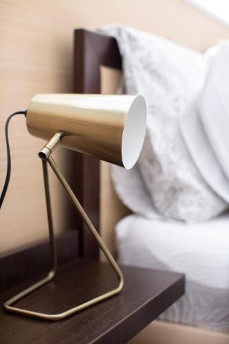 a lamp on a table next to a bed at Casa Merano Residence & Restaurant Bibione Centro in Bibione
